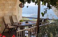 SpartýlasLorantina Luxury Sea View Holiday House close to Barbati &amp; Ipsos Beach with Starlink WiFi的阳台上的桌子和椅子，可以欣赏美景