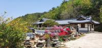 江陵市Gangneung Wangsangoal Hanok Pension的一栋建筑前有一束鲜花