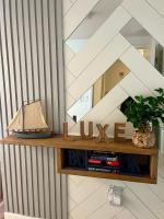 默特尔比奇Luxe by the Sea - 5-Star Beachfront Escape的一个带镜子和书籍的木架