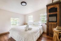 奥斯汀Cozy Coop Casita - Lake Travis-Hot Tub-Tiny House的一间卧室配有两张床、白色床单和窗户。