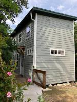 奥斯汀Cozy Coop Casita - Lake Travis-Hot Tub-Tiny House的灰色的房子,设有门廊和2个窗户