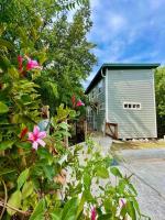 奥斯汀Cozy Coop Casita - Lake Travis-Hot Tub-Tiny House的一座房子,前面有一座建筑和鲜花