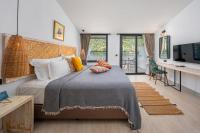 厄吕代尼兹Ölüdeniz Blu Luxury Unique Hotel - Adults-Only的一间卧室，配有一张床和一张带电视的书桌