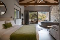 梅加克瑞奥Evora Luxury Suites的一间卧室配有一张床、一个浴缸和一张沙发