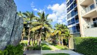 南芭堤雅unixx seaview hotel的享有棕榈树建筑和人行道的景色