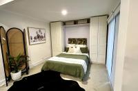 鲸滩Avalon Beach Guesthouse的一间卧室,里面装有床和植物