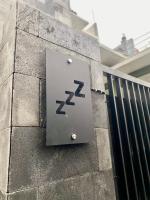 玛琅Zzz Hostel Malang的建筑物一侧的金属标志