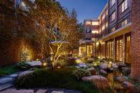 成都Chuanxing Yinli Hotel Chengdu Kuanzhai Alley Branch, with free welcome wine and afternoon tea的一栋建筑的庭院，有树和灯