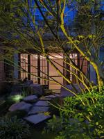成都Chuanxing Yinli Hotel Chengdu Kuanzhai Alley Branch, with free welcome wine and afternoon tea的有岩石的花园和有围栏的建筑