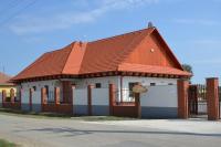 JászladányJász Vendégház的一座带橙色屋顶和围栏的小建筑