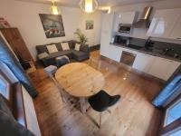 夏蒙尼-勃朗峰Cham&#39;Heart, 4-star apartments in Chamonix centre with free private parking的客厅和带木桌的厨房,享有高空美景。