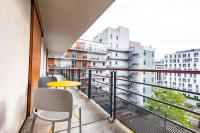 格勒诺布尔Apparthotel Le Hüb Grenoble的阳台配有黄色桌子和椅子,并拥有建筑