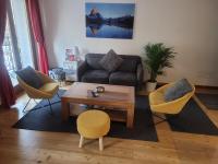 夏蒙尼-勃朗峰Cham&#39;Heart, 4-star apartments in Chamonix centre with free private parking的客厅里有一张沙发、两把椅子和一张桌子