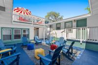 默特尔比奇4BR2BA Sleeps 12 Pet-Friendly Steps to Beach的庭院配有蓝色的椅子和遮阳伞。