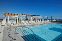 德斯坦Hotel Effie Sandestin Resort, Autograph Collection的一个带白色椅子的游泳池和一个泳池景