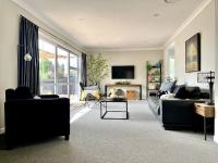 汉密尔顿M&amp;K Home with central air condition, 4 bedrooms, by Chartwell Shopping Centre的有两张沙发和一台电视的客厅