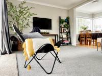 汉密尔顿M&amp;K Home with central air condition, 4 bedrooms, by Chartwell Shopping Centre的客厅里一张带毯子的椅子