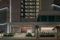 默特尔比奇Courtyard by Marriott Myrtle Beach Oceanfront的一座棕榈树在晚上的建筑
