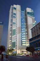 默特尔比奇Courtyard by Marriott Myrtle Beach Oceanfront的一座大楼，前面有人走动