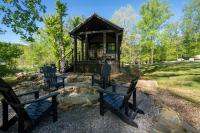 加特林堡Tiny Home Firepit BBQ Fishing Willow Cabin的凉亭配有四把椅子和一只狗