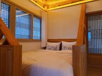 庆州Hanok stay Mokhyang的带一张床和两扇窗户的卧室