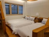 庆州Hanok stay Mokhyang的有两张床的房间有两扇窗户