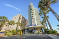 默特尔比奇The 7th Heaven in Myrtle Beach的一座前面有棕榈树的建筑