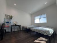 洛杉矶The Blue Hostel的有两张床、一张桌子和一扇窗户的房间