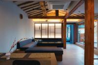 江陵市Gangneung Jeodong Hanok Pension newly built的客厅里有一张蓝色沙发和一台电视