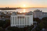 德斯坦Hotel Effie Sandestin Resort, Autograph Collection的一座白色的大建筑,背面是日落