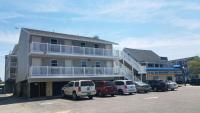 大洋城Atlantic Breeze Motel &amp; Apartments的停车场里停着汽车的建筑物