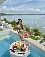 道伊斯Epic Suites Bohol ADULTS ONLY的坐在游泳池边的女人,拿着一盘食物