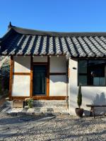 江陵市Bow Hanok House的前面有盆栽的小房子