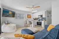 默特尔比奇Sea Cabin 118 - Oceanfront的带蓝色沙发的客厅和厨房