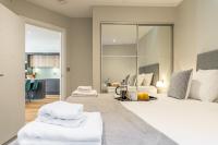 雷丁Bond House by Celador Apartments的一间卧室配有一张大床和两条白色毛巾