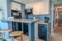 默特尔比奇Ocean View Double Suite! Sleeps 4 Meridian Plaza 705的厨房配有白色橱柜和带凳子的台面