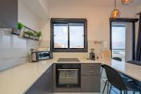 埃拉特Amalfi Apartment - By Harim的厨房配有台面和2扇窗户