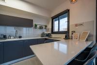 埃拉特Amalfi Apartment - By Harim的厨房配有大型白色柜台和窗户。
