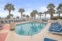 默特尔比奇Coastal Comfort Your Perfect Beachfront Getaway的一个带蓝色椅子的游泳池,棕榈树