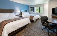 卡森市My Place Hotel-Carson City, NV的有两张床和一张书桌的酒店房间
