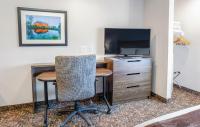 卡森市My Place Hotel-Carson City, NV的客房设有书桌、电视、桌子和椅子。