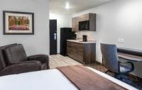卡森市My Place Hotel-Carson City, NV的酒店客房带椅子和床,还有厨房