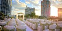 迈阿密海滩Hilton Bentley Miami South Beach的建筑物前一排白色的桌椅