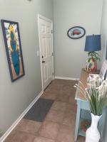 格尔夫海岸Beautiful Two Bedroom, Two Bathroom First Floor Condo in Gulf Shores!的走廊上挂着一张桌子和一张墙上的照片