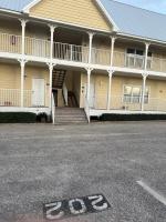 格尔夫海岸Beautiful Two Bedroom, Two Bathroom First Floor Condo in Gulf Shores!的一座黄色的大建筑,设有楼梯和门廊