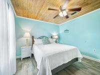 格尔夫海岸Bungalow by the Bay with FREE ACTIVITIES的带床和吊扇的卧室