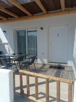Agia Kiriaki BeachAperanto galazio的带桌椅和门的露台