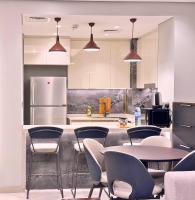 迪拜CaiCai Homes 1 BHK Nobles Tower Business Bay 5 min Drive to Dubai Mall的厨房配有桌椅和冰箱。