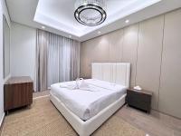 迪拜CaiCai Homes 1 BHK Nobles Tower Business Bay 5 min Drive to Dubai Mall的卧室配有一张白色大床和吊灯。