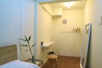曼谷Les Fleurs Bangkok Hostel的卧室里有一张床，墙上挂着一个钟